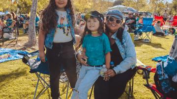 Group of people at a concert in the park.