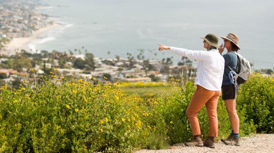 Two hikers on a trail overlooking the Pacific Ocean