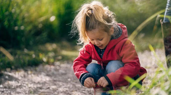 Girl kneeling down and looking at the trail