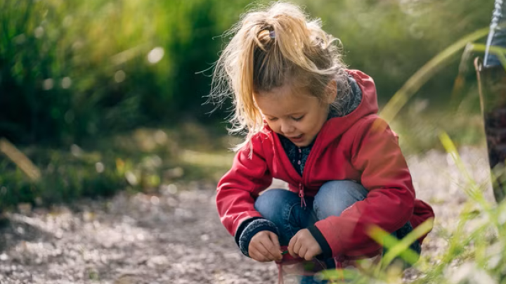 Girl kneeling down and looking at the trail
