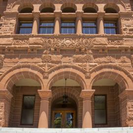 Old historical red stone building entrance with three arches