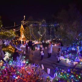 People stroll the decorated grounds of Heritage Hill Historical Park at Candlelight Walk