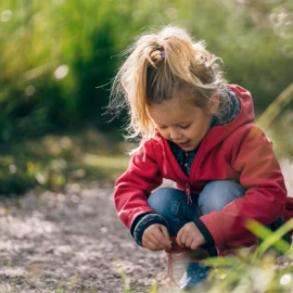 Girl kneeling down and looking at the trail