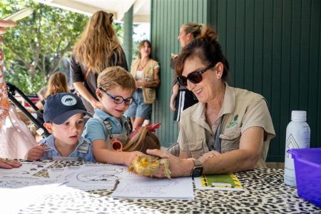 Volunteer doing crafts with visitors at the OC Zoo.